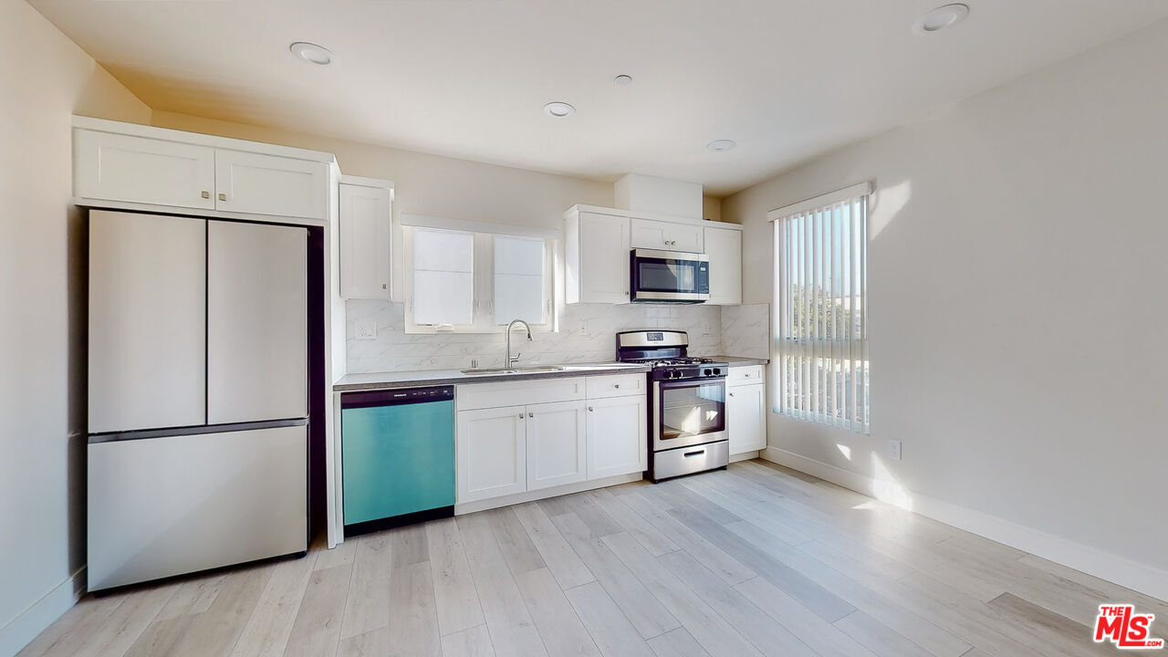 252 Rosemont Avenue, Unit 1/2 Los Angeles, CA 90026 - Photo 2 of 30 a kitchen with white cabinets and stainless steel appliances