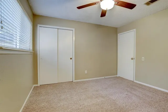 an empty room with a chandelier fan
