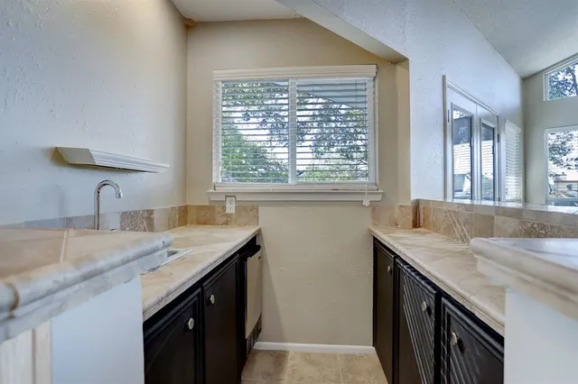 a kitchen with a granite countertop sink a window and a counter