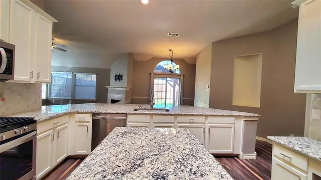 a kitchen with a stove sink and cabinets