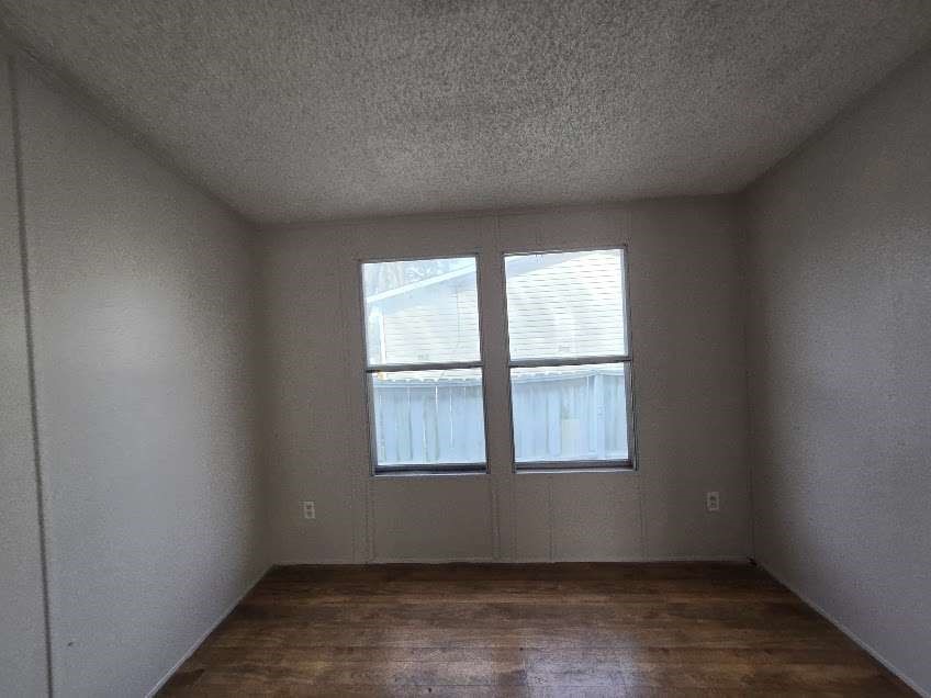 5815 Dylan Drive Baytown, TX 77521 - Photo 4 of 7 an empty room with wooden floor and windows