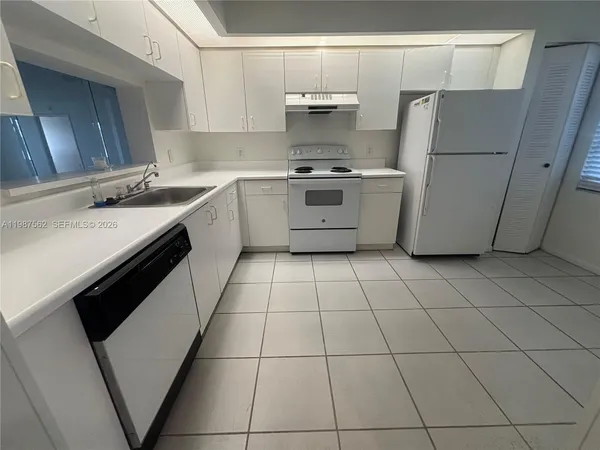 a kitchen with a sink a stove a refrigerator and cabinets