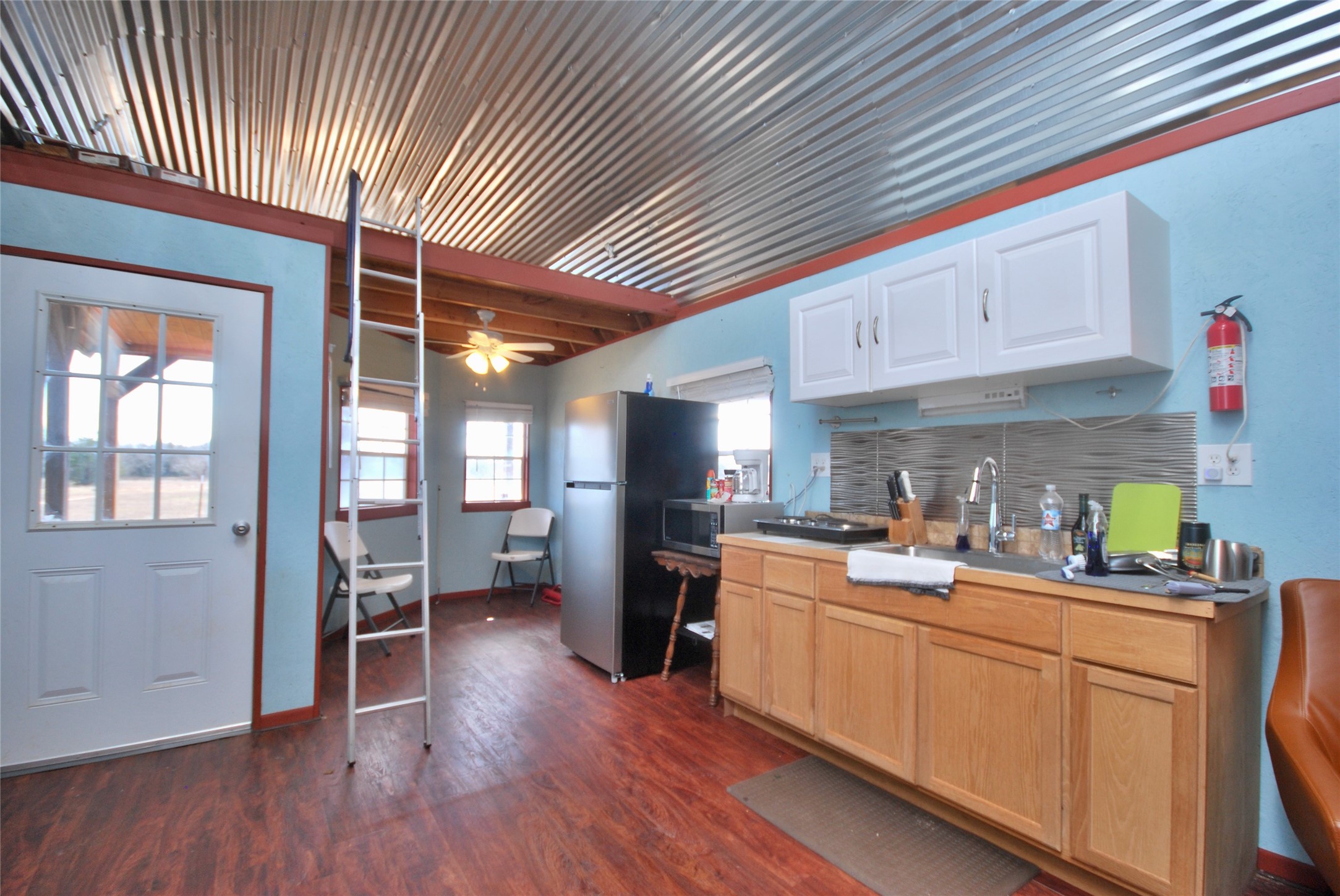 4850 Burke Road Flatonia, TX 78941 - Photo 16 of 45 a kitchen with stainless steel appliances granite countertop a refrigerator a sink dishwasher a stove and white countertops with wooden floor
