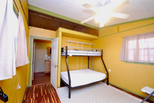 a bedroom with a bed and wooden floor