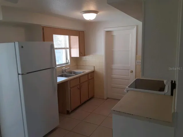 a kitchen with a refrigerator sink and cabinets