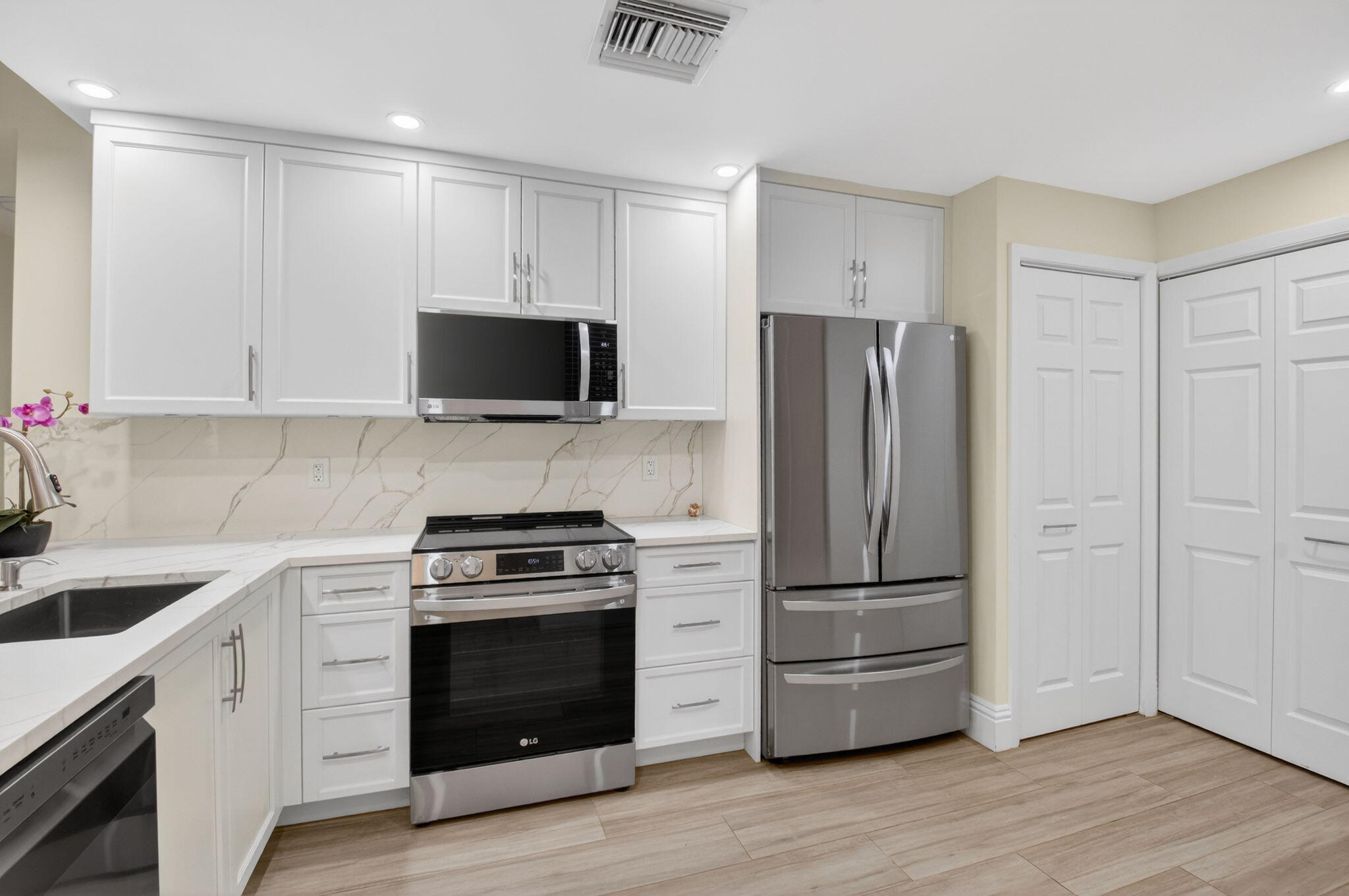 7484 La Paz Boulevard, Unit 103 Boca Raton, FL 33433 - Photo 16 of 50 a kitchen with a refrigerator stove and wooden cabinets