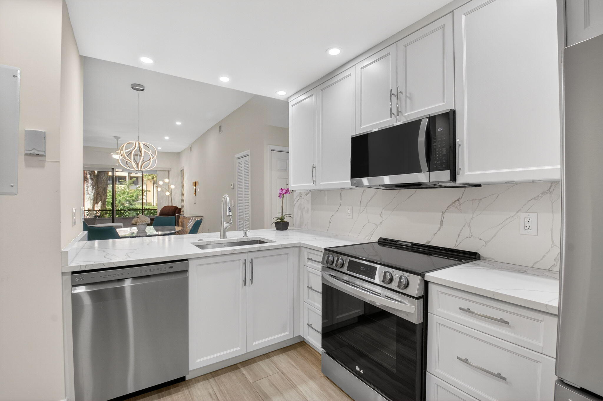 7484 La Paz Boulevard, Unit 103 Boca Raton, FL 33433 - Photo 20 of 50 a kitchen with a sink stove and microwave