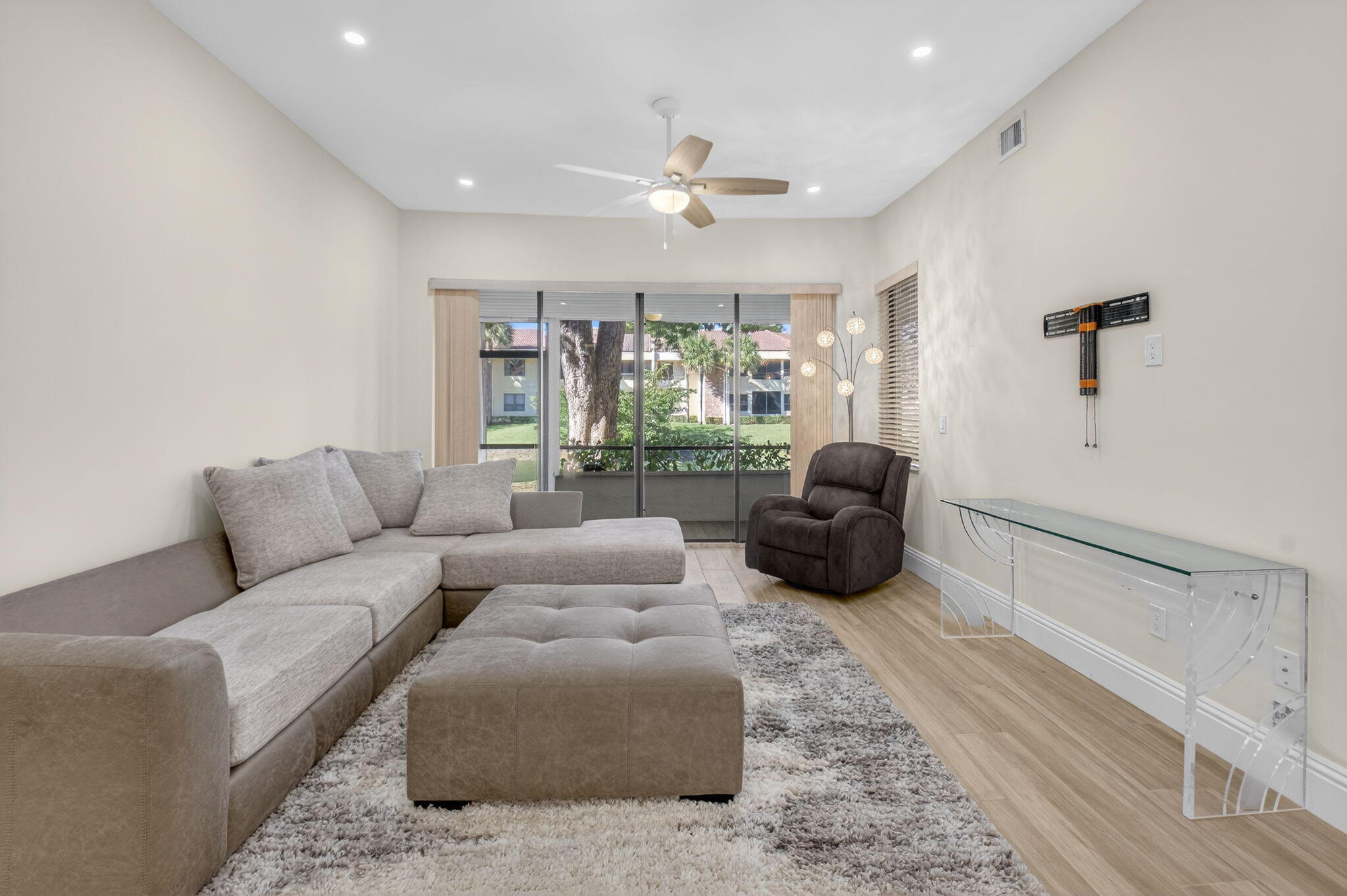 7484 La Paz Boulevard, Unit 103 Boca Raton, FL 33433 - Photo 2 of 50 a living room with furniture ceiling fan and a rug