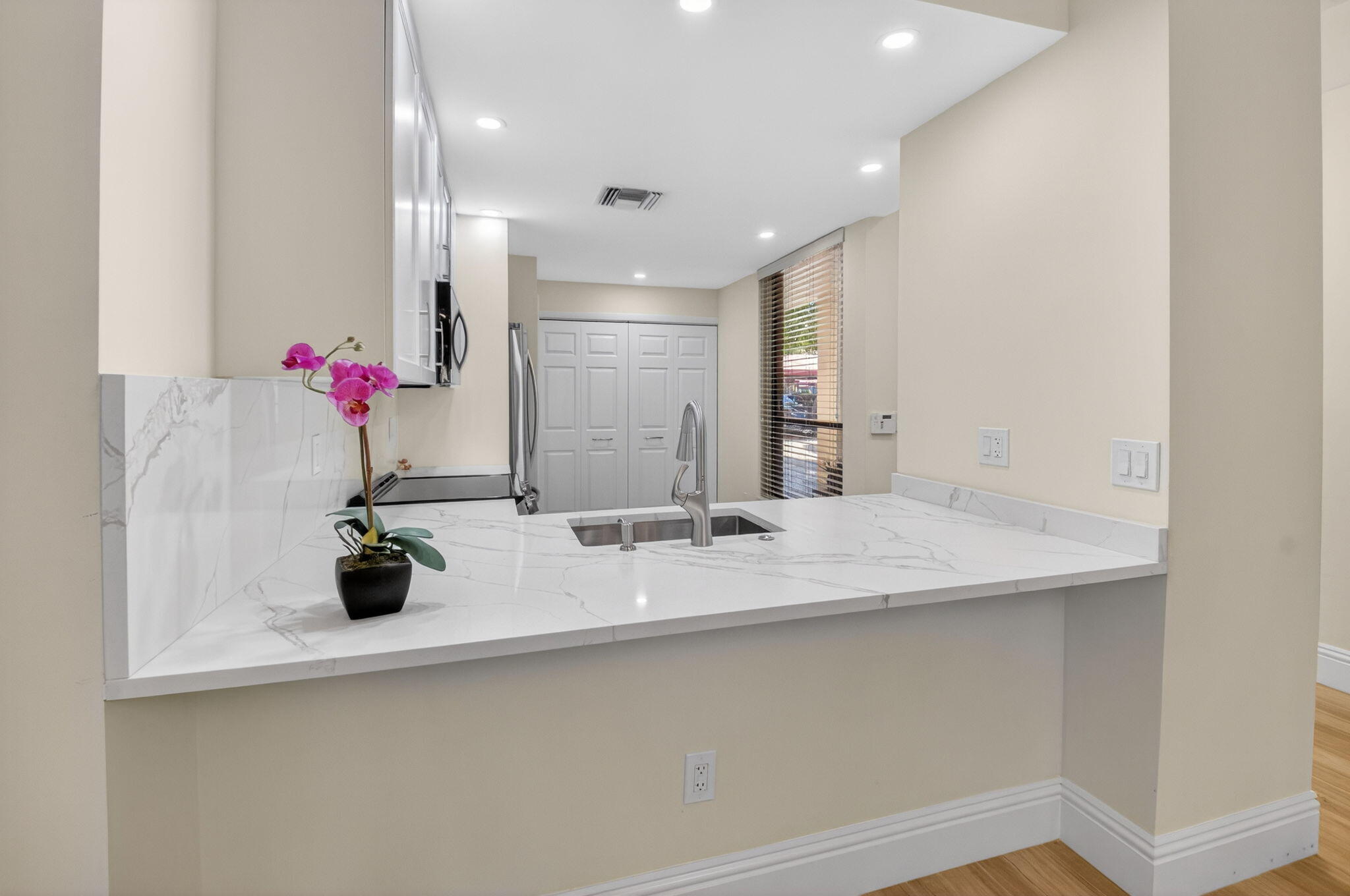 7484 La Paz Boulevard, Unit 103 Boca Raton, FL 33433 - Photo 21 of 50 a view of counter top a sink and dishwasher with wooden floor