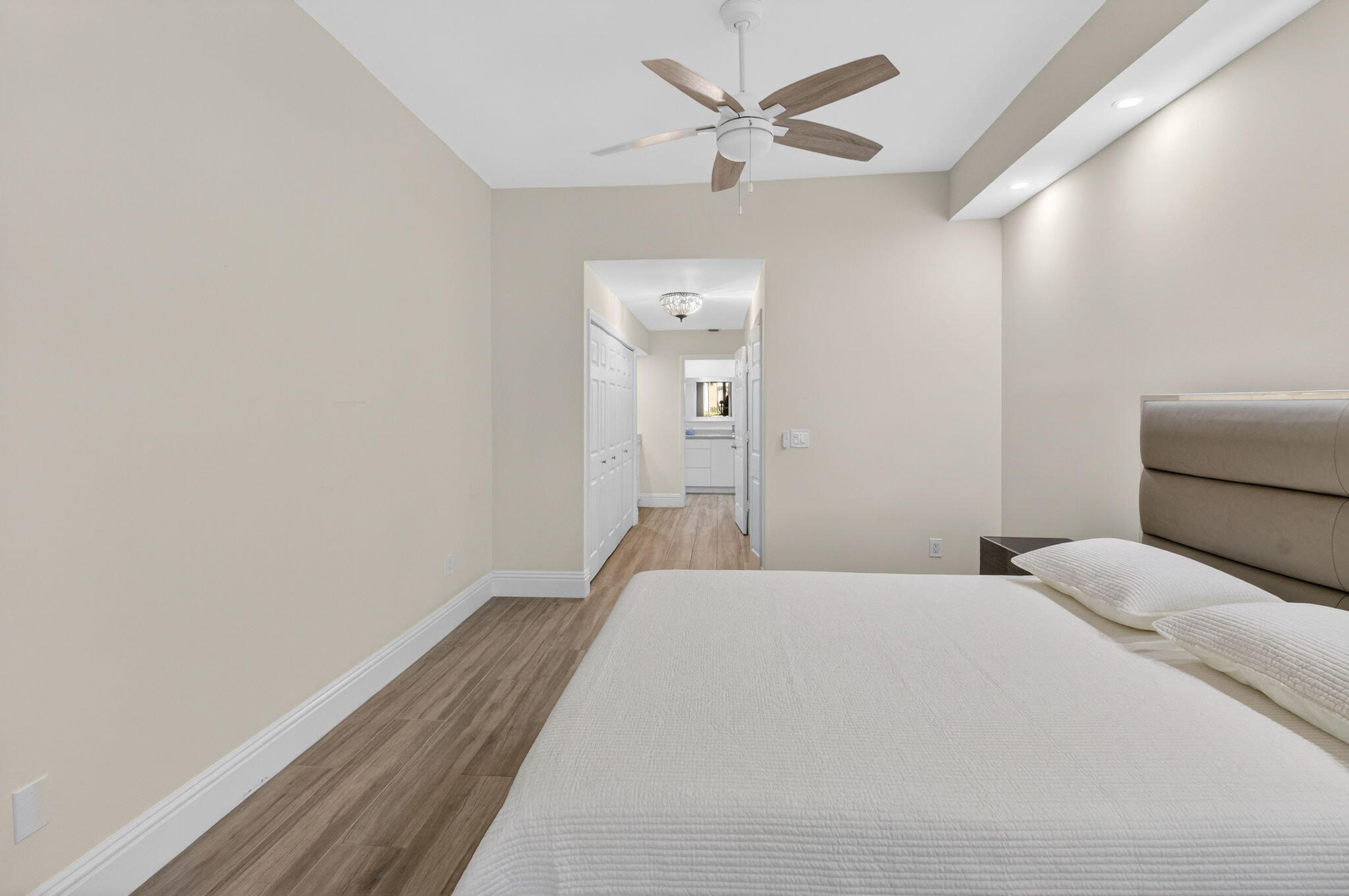 7484 La Paz Boulevard, Unit 103 Boca Raton, FL 33433 - Photo 25 of 50 a bedroom with a bed and a chandelier