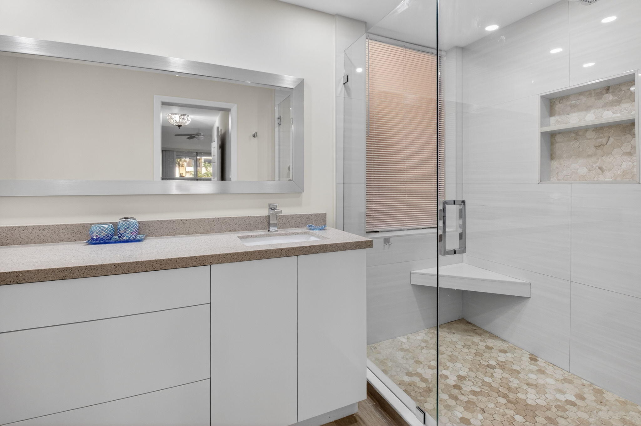 7484 La Paz Boulevard, Unit 103 Boca Raton, FL 33433 - Photo 27 of 50 a bathroom with a double vanity sink a mirror and a shower