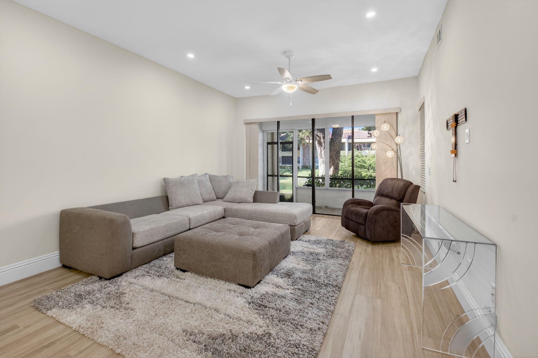 7484 La Paz Boulevard, Unit 103 Boca Raton, FL 33433 - Photo 3 of 50 a living room with furniture and a flat screen tv