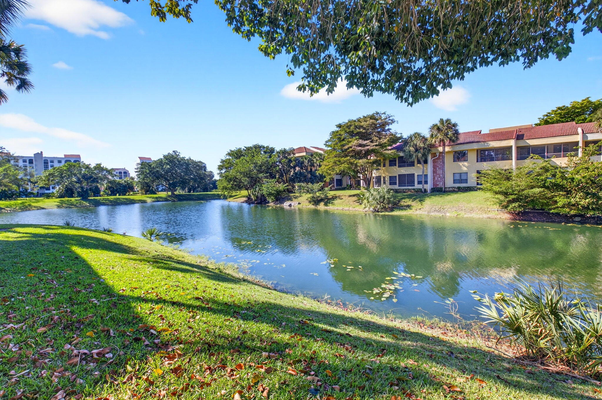 7484 La Paz Boulevard, Unit 103 Boca Raton, FL 33433 - Photo 5 of 50 a view of a lake with a house in the background