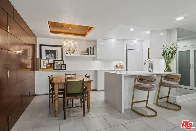 a kitchen with a dining table chairs and refrigerator