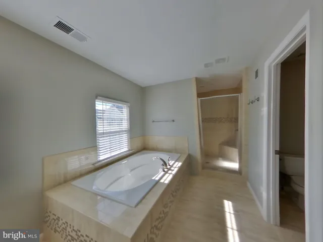 a spacious bathroom with a tub shower and a sink