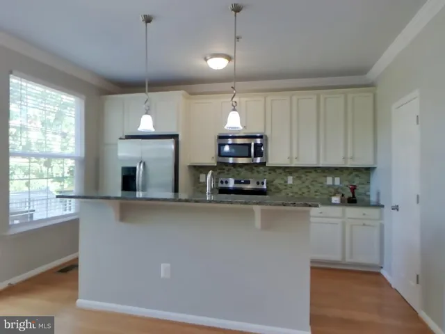 a kitchen with stainless steel appliances a sink a stove a refrigerator and window