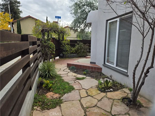 a view of a house with a yard and a bench