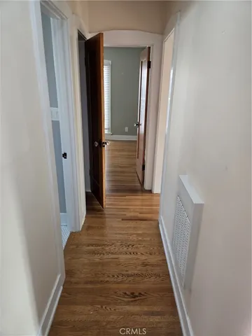 a view of a hallway with wooden floor and staircase