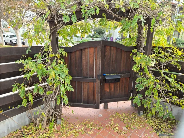 a view of a backyard with potted plants and large trees