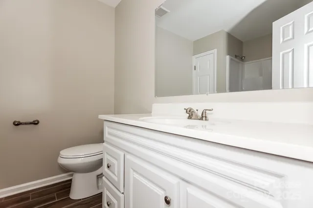 a bathroom with a granite countertop toilet sink and a mirror