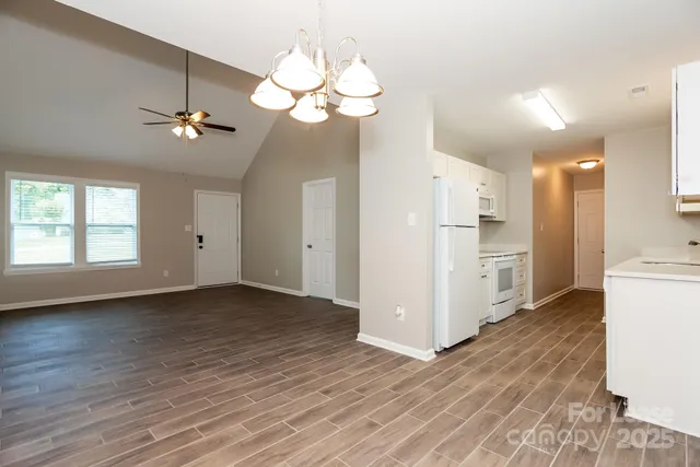 a view of a kitchen with wooden floor and a large window