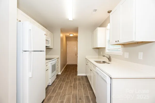 a kitchen with white cabinets and white appliances
