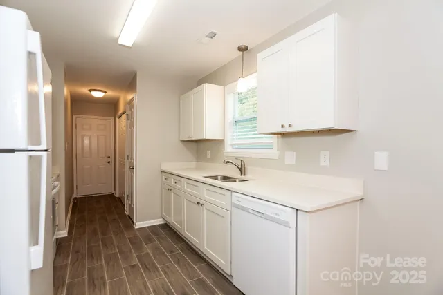a kitchen with a sink cabinets stainless steel appliances and a window