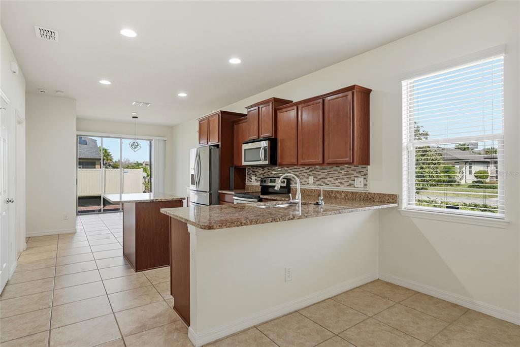 1724 Passage Key Lane Ruskin, FL 33570 - Photo 12 of 46 a large kitchen with stainless steel appliances granite countertop a sink and cabinets