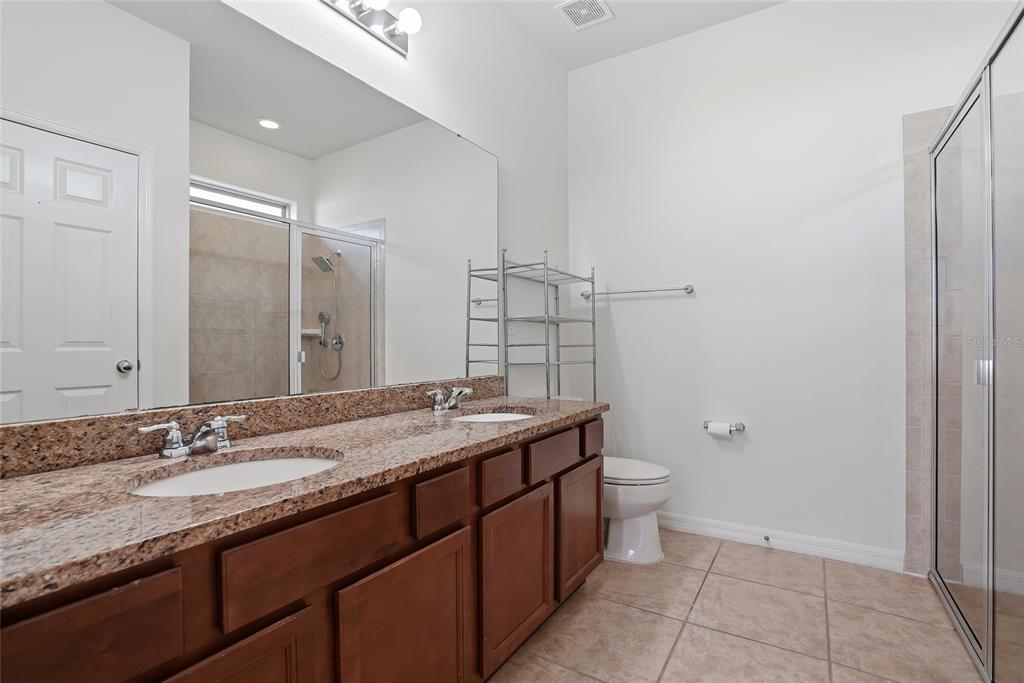 1724 Passage Key Lane Ruskin, FL 33570 - Photo 29 of 46 a bathroom with a granite countertop sink a toilet and a mirror