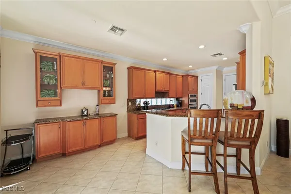 a kitchen with stainless steel appliances granite countertop a table chairs sink and cabinets