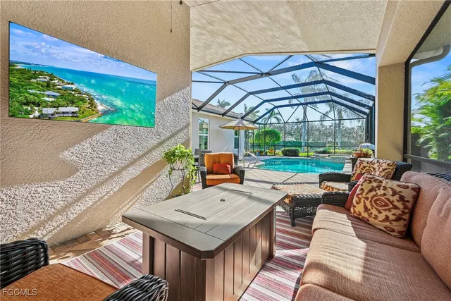 a view of a patio with couches table and chairs under an umbrella with a fire pit