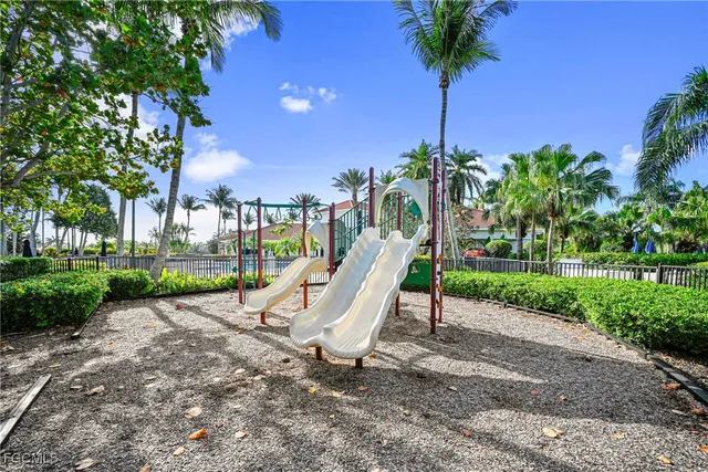 a view of a park with a slide and potted plants