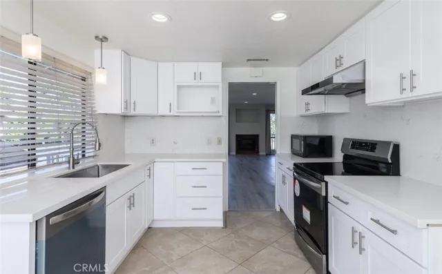 a kitchen with stainless steel appliances a stove sink and cabinets