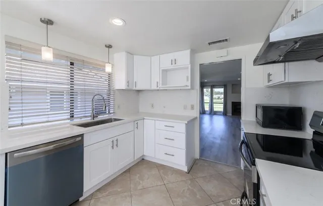 a kitchen with granite countertop a sink a stove and cabinets