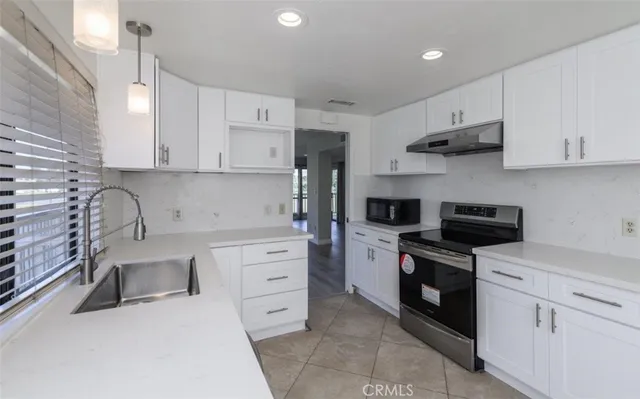 a kitchen with stainless steel appliances a stove sink and cabinets
