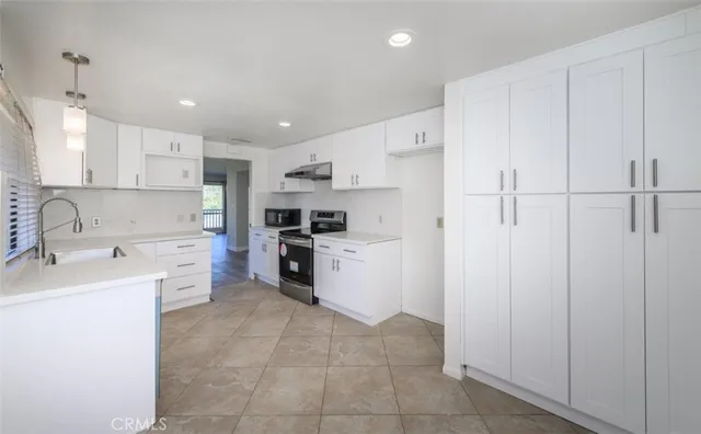 a kitchen with white cabinets and white appliances