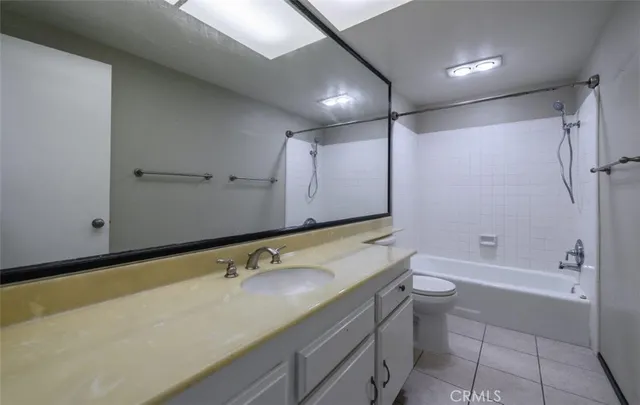 a bathroom with a granite countertop sink a toilet and shower