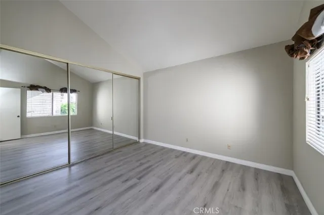 an empty room with wooden floor and window