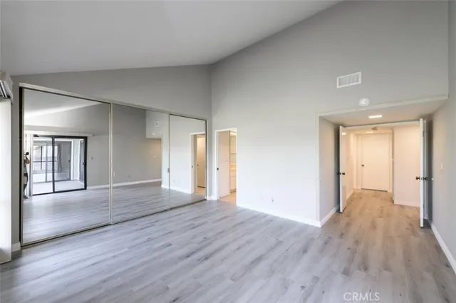 a view of a big room with wooden floor and windows