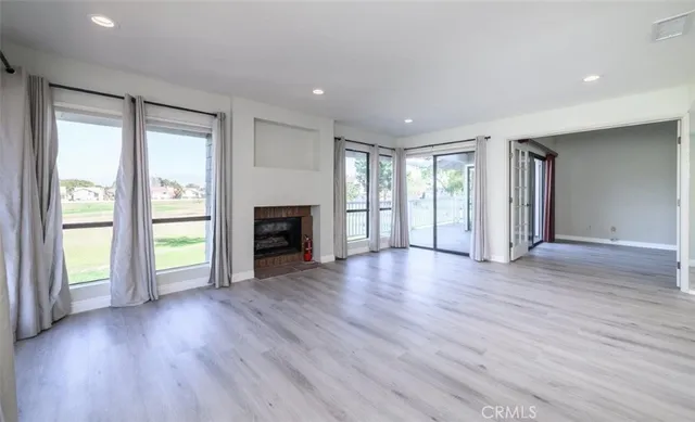 an empty room with wooden floor and fireplace