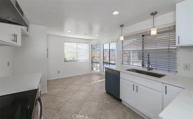 a large white kitchen with sink and window