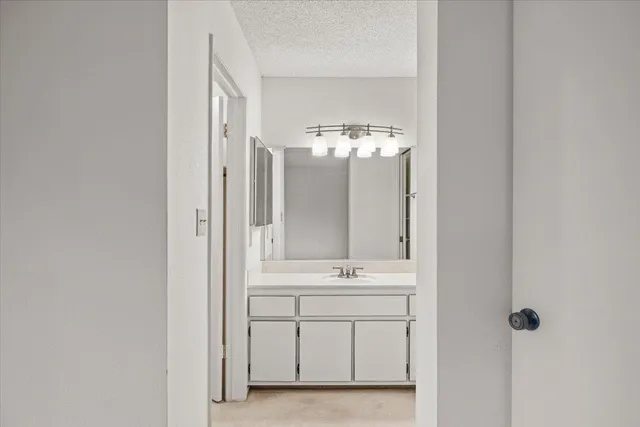 a bathroom with a granite countertop sink a mirror and a shower