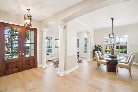 a dining room with furniture a chandelier and wooden floor
