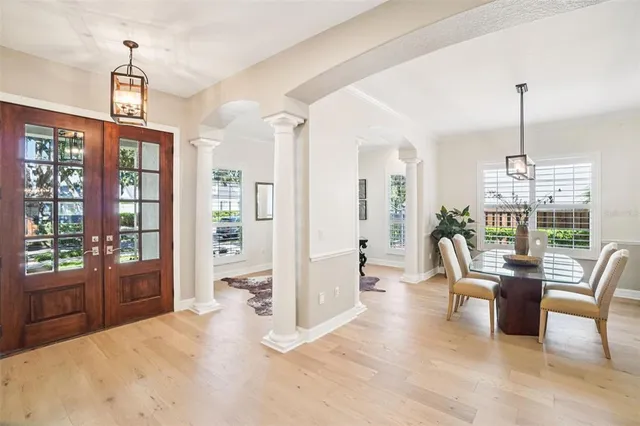 a dining room with furniture a chandelier and wooden floor