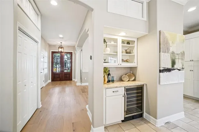 a view of a dining room and livingroom with furniture wooden floor a chandelier
