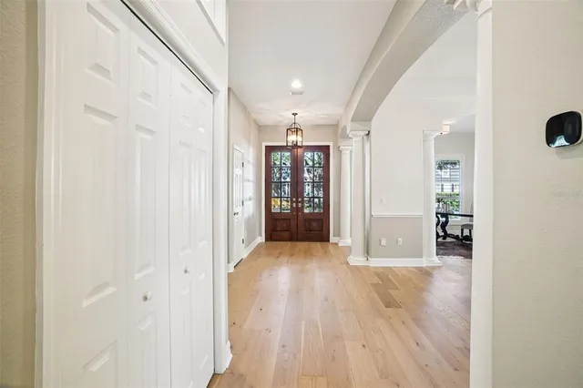 a dining room with furniture a rug a potted plant and wooden floor