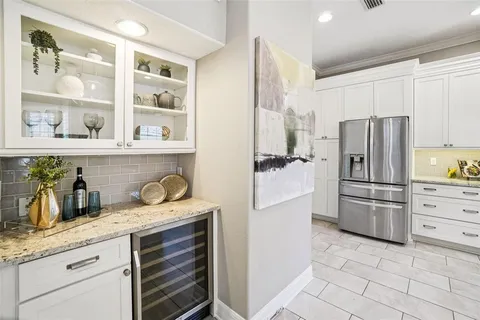a bathroom with a granite countertop tub a double vanity sink a mirror and a shower