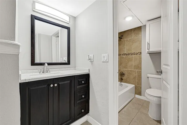 a bathroom with a toilet a sink a mirror a shower a vanity and window