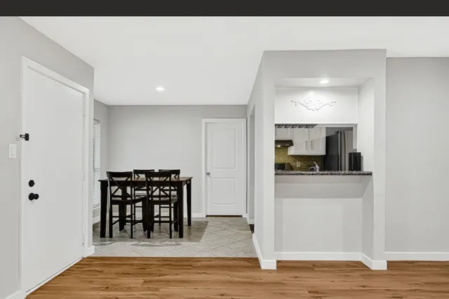 a view of kitchen with stainless steel appliances granite countertop a refrigerator and a stove top oven