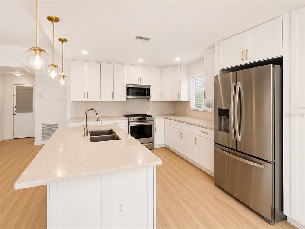 338 Mantis Loop Apopka, FL 32703 - Photo 5 of 11 a kitchen with stainless steel appliances a refrigerator sink and microwave